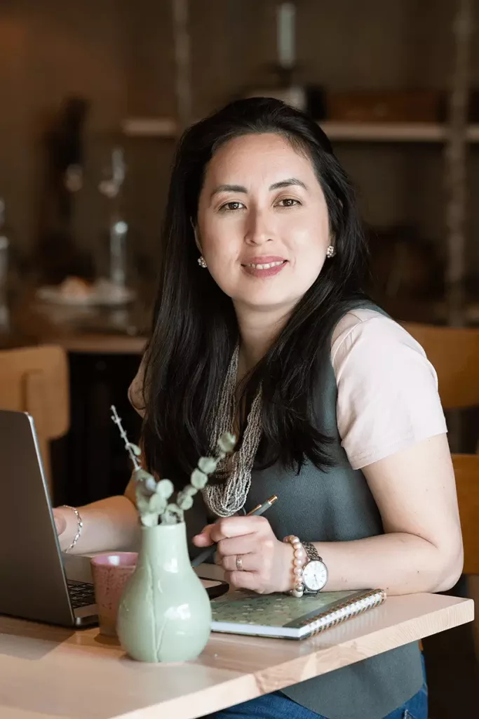 Career coach Bruna Mathys in a bright, modern office, actively listening during a coaching session.